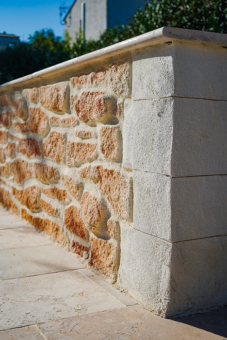 Mur de clôture extérieur en pierres naturelles apparentes, tons ocre et beige