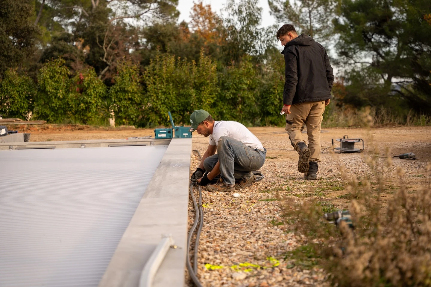 Terrasse extérieure en dalles de pierre naturelle bordant une piscine turquoise