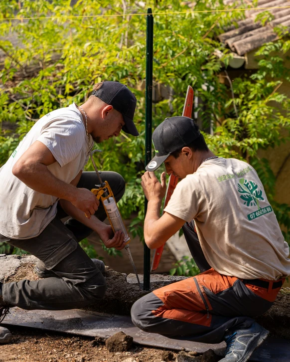 Aménagement paysager extérieur avec massif floral coloré bordant une pelouse verte
