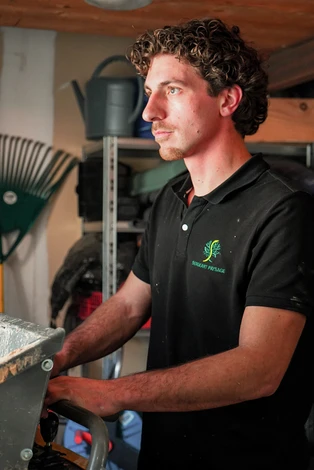 Un homme plante des genévriers dans la cour