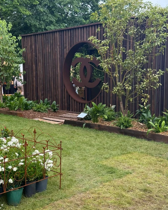 Jardin paysager extérieur avec massif rocheux aménagé, pelouse entretenue, plantation mixte de vivaces et arbustes