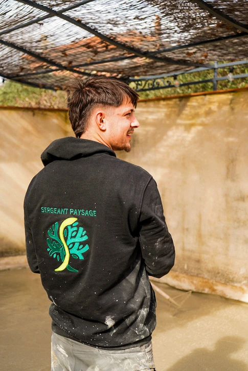 Jardin extérieur moderne avec terrasse en dalles de pierre naturelle grise, mur de soutènement en pierres plates stratifiées