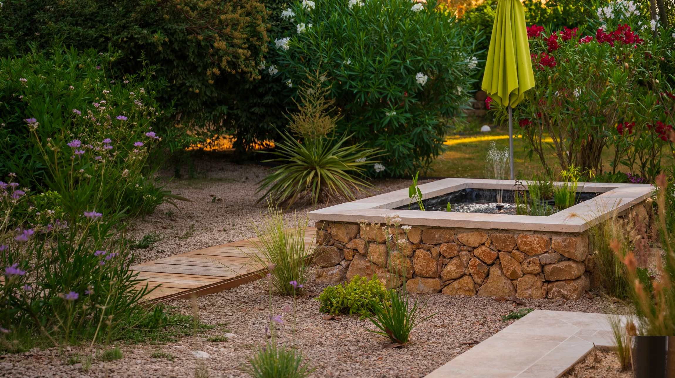 Escalier extérieur en pierres naturelles grises dans un jardin paysager avec mousse verte et feuillage automnal au sol