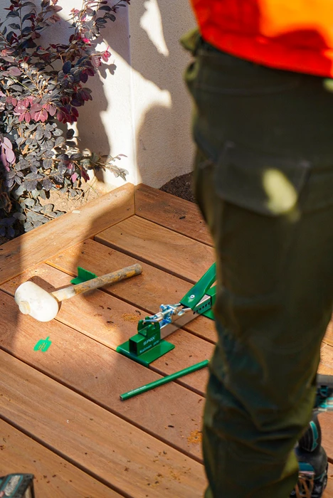 Terrasse extérieure en cours d'aménagement avec pose de dalles en pierre naturelle beige selon un motif géométrique irrégulier
